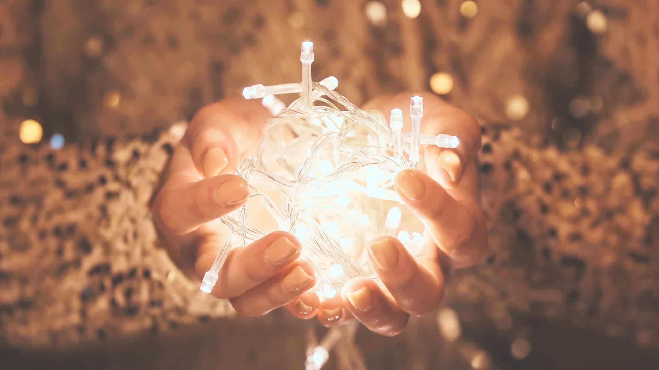Glowing fairy lights in a womans hands