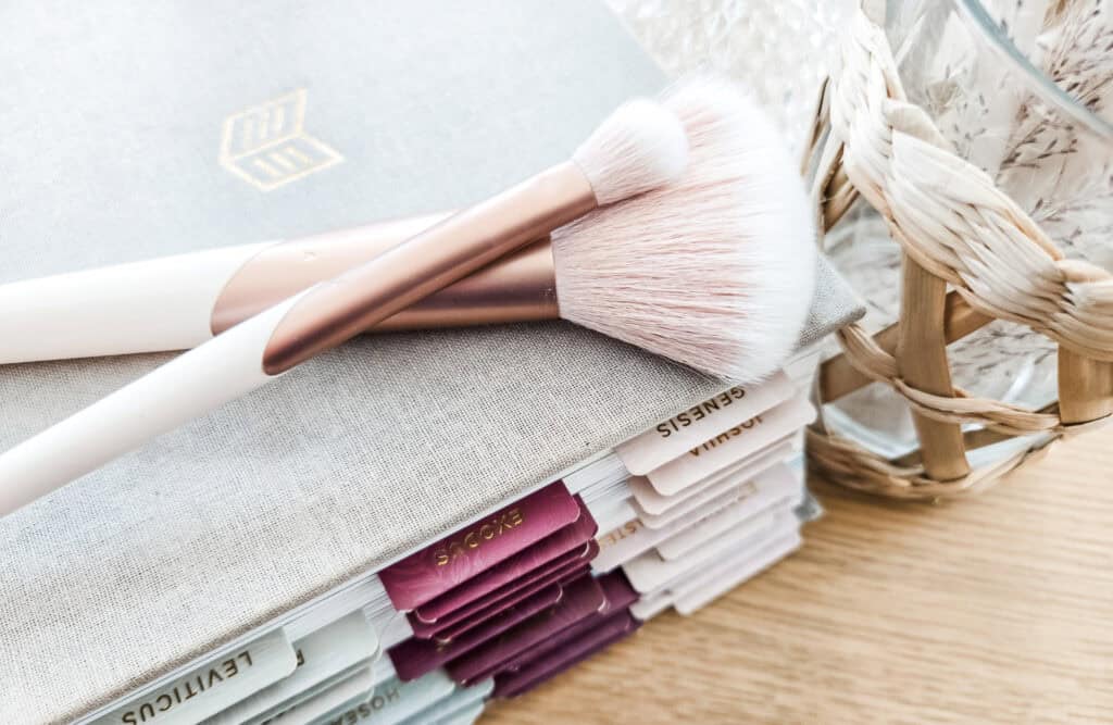 Bible with makeup brushes and perfume bottle